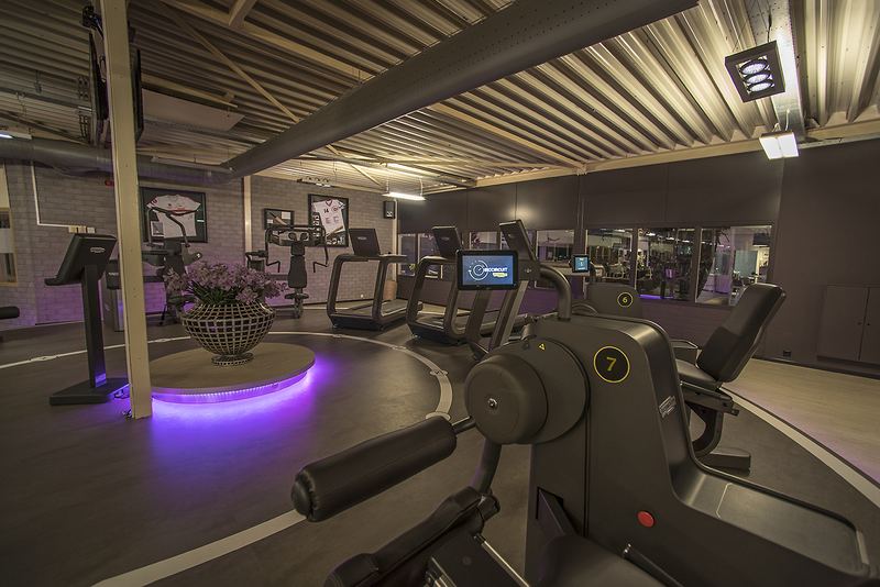 De trainingszaal van Warren's met het verlichte podium en Technogym-apparatuur